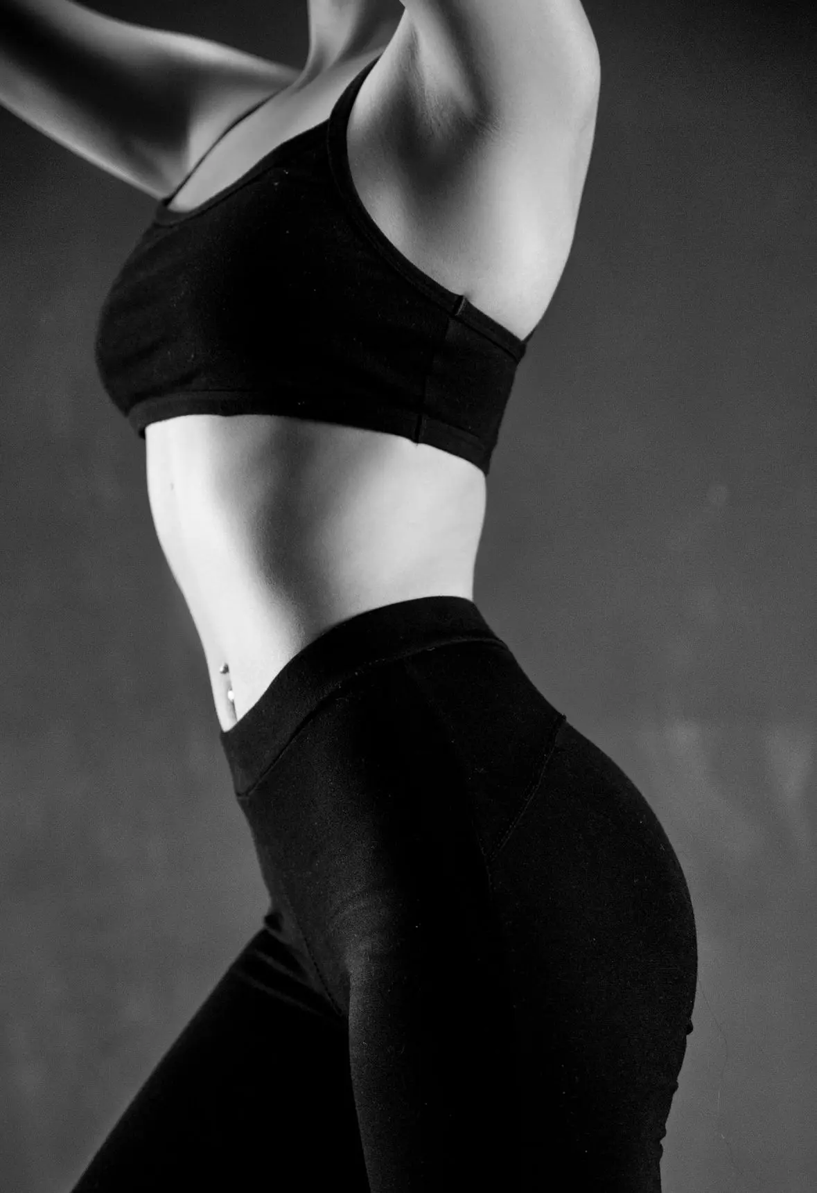 grayscale photo of person wearing sports bra and leggings